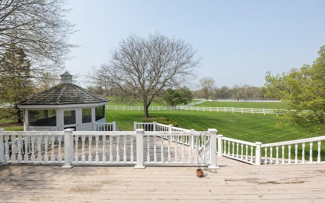 wooden deck with a rural view and a yard