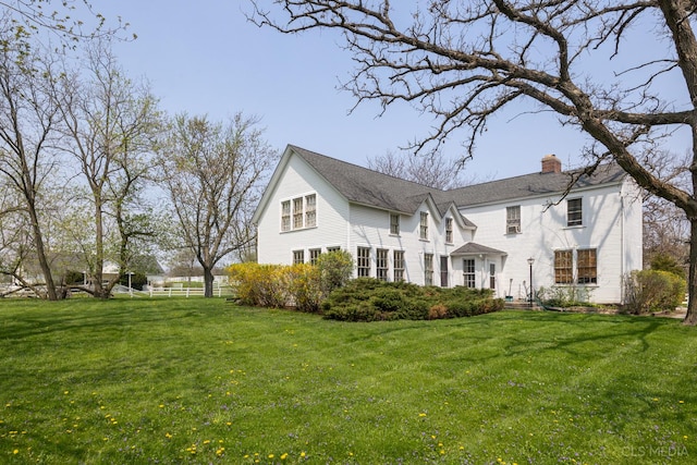 rear view of house featuring a yard