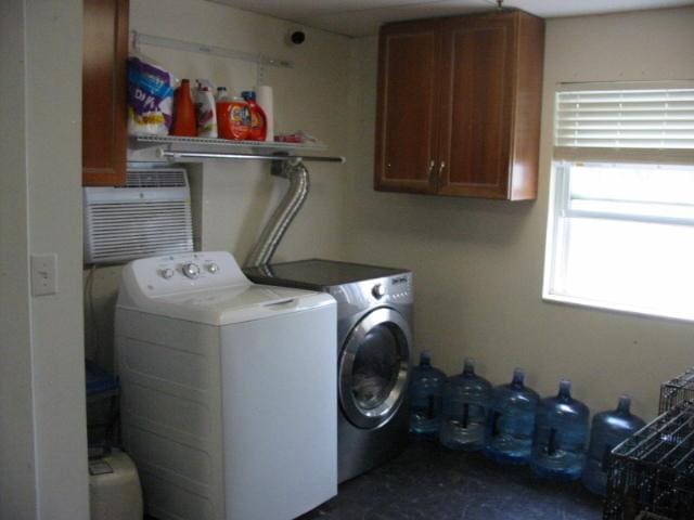 clothes washing area with washing machine and dryer and cabinets