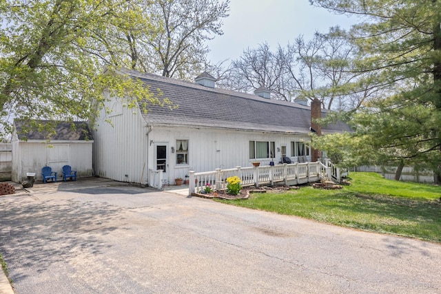 view of front of home with a wooden deck and a front lawn