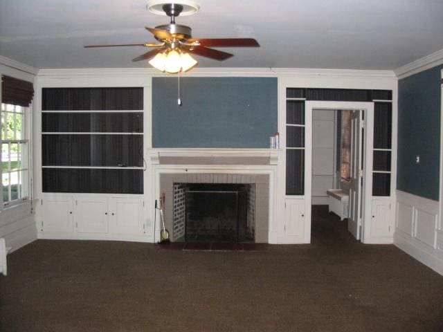 unfurnished living room with crown molding, ceiling fan, and dark colored carpet