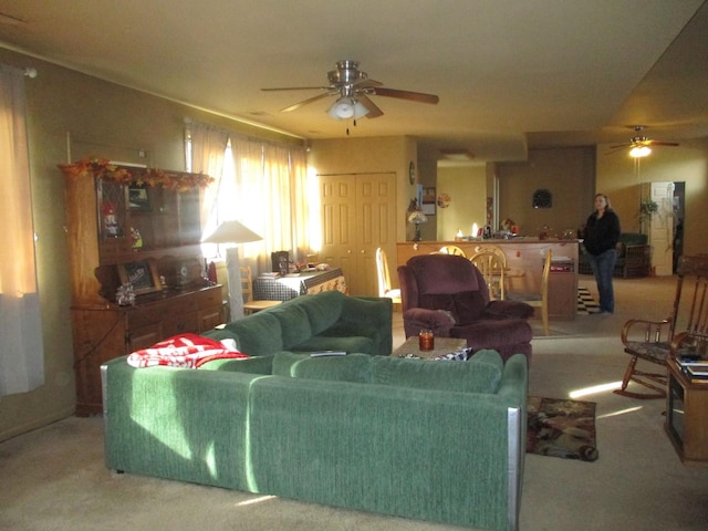 carpeted living room with ceiling fan