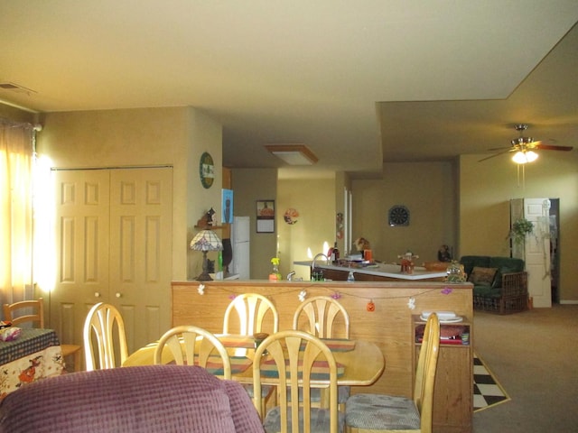 kitchen featuring ceiling fan, kitchen peninsula, and carpet floors