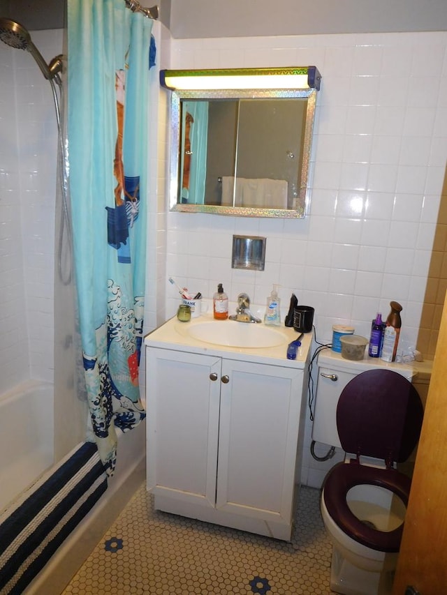 full bathroom with tile walls, backsplash, toilet, vanity with extensive cabinet space, and shower / bath combo with shower curtain