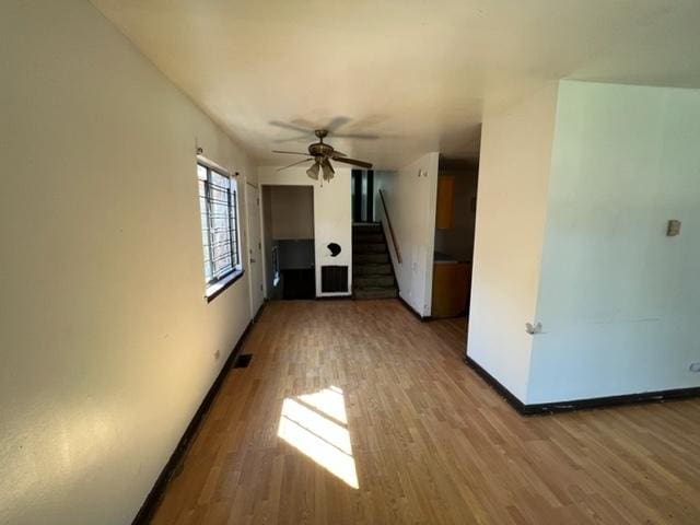 unfurnished room with ceiling fan and dark wood-type flooring