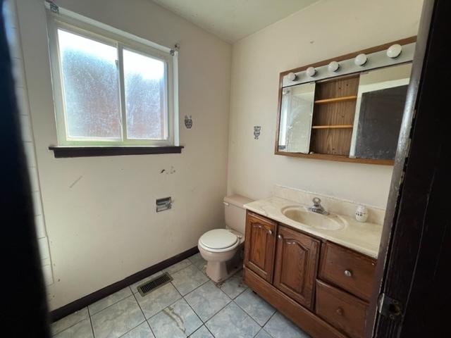 bathroom featuring vanity, tile flooring, and toilet