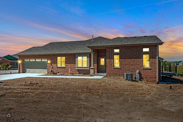 view of front of house with central AC and a garage