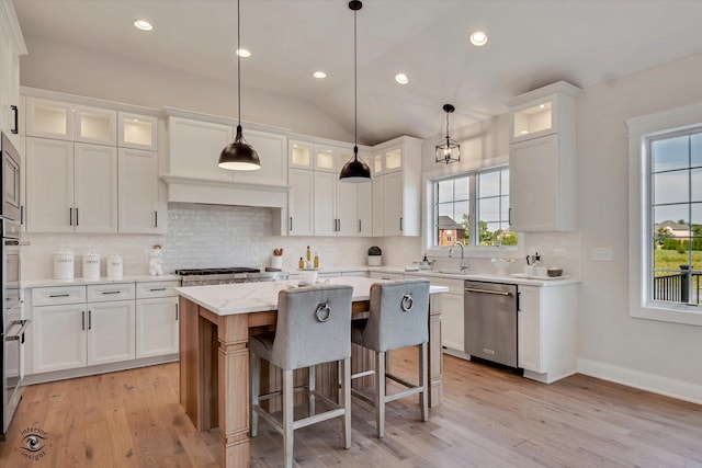 kitchen with plenty of natural light, a kitchen island, decorative light fixtures, and dishwasher