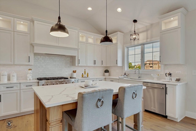 kitchen featuring a kitchen bar, pendant lighting, a center island, and dishwasher