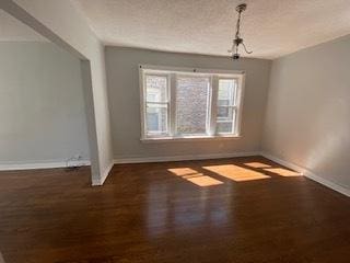 empty room featuring dark hardwood / wood-style flooring and a textured ceiling