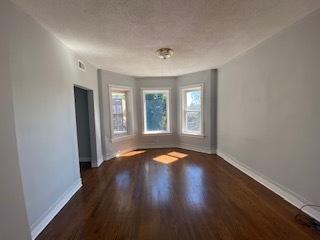 unfurnished room featuring a textured ceiling and dark hardwood / wood-style floors