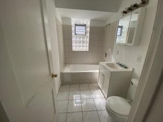 full bathroom with tiled shower / bath, toilet, large vanity, and tile flooring