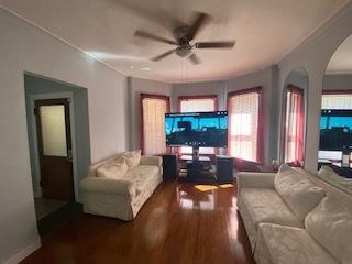 living room with dark hardwood / wood-style floors and ceiling fan