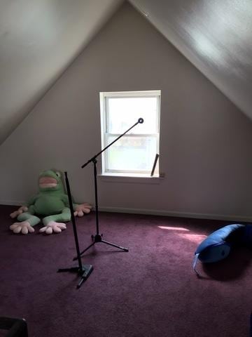 bonus room with lofted ceiling and dark carpet