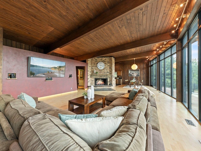 living room with a brick fireplace, wood ceiling, and light hardwood / wood-style flooring