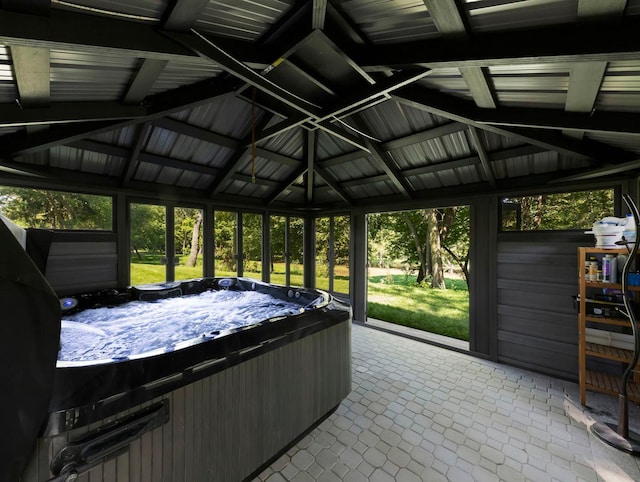 sunroom / solarium with lofted ceiling and a hot tub