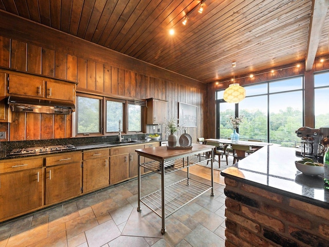 kitchen with custom range hood, dark stone countertops, sink, wooden ceiling, and stainless steel gas stovetop