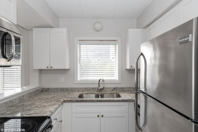 kitchen with white cabinets, appliances with stainless steel finishes, a healthy amount of sunlight, and sink