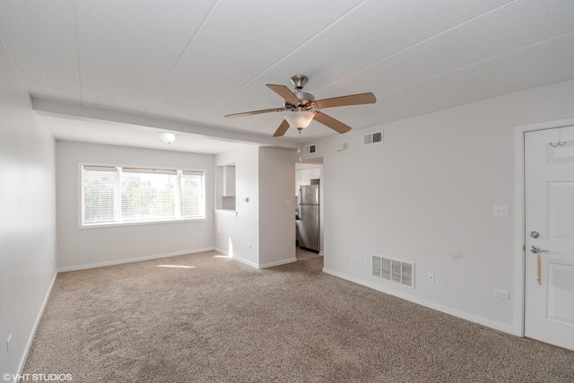 unfurnished bedroom featuring ceiling fan, stainless steel refrigerator, and light colored carpet