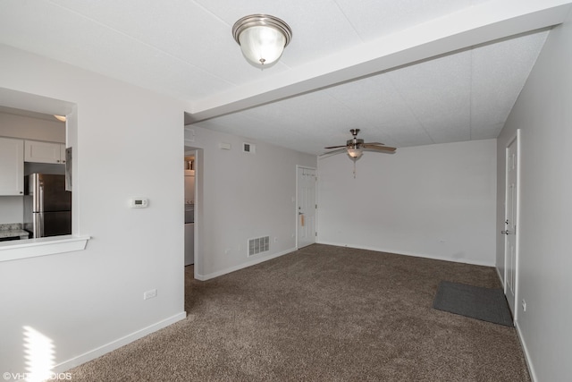 spare room featuring ceiling fan and dark carpet