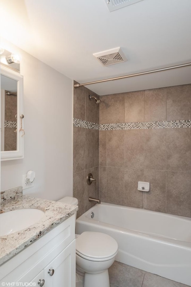 full bathroom featuring tiled shower / bath combo, tile flooring, toilet, and vanity with extensive cabinet space