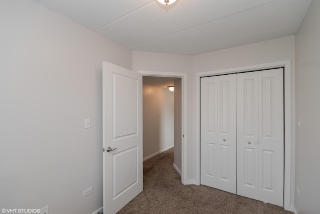 unfurnished bedroom featuring a closet and dark colored carpet