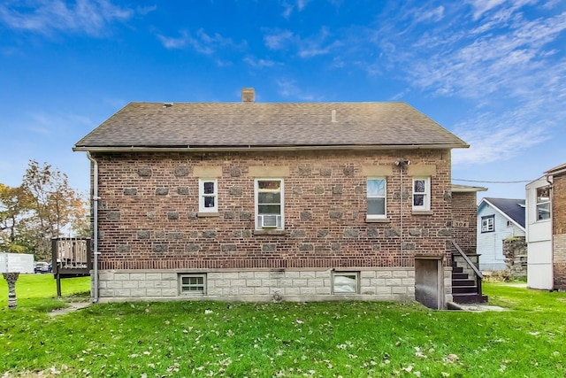 back of property with a deck and a lawn