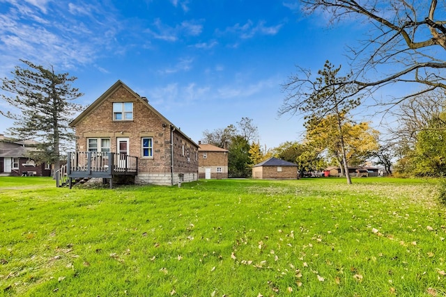 rear view of house featuring a wooden deck and a yard