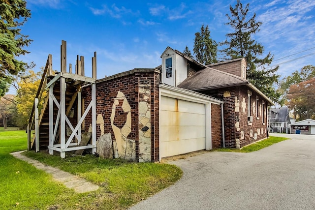 view of side of property with a yard and a garage