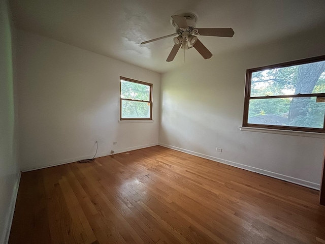 empty room with ceiling fan and light hardwood / wood-style flooring