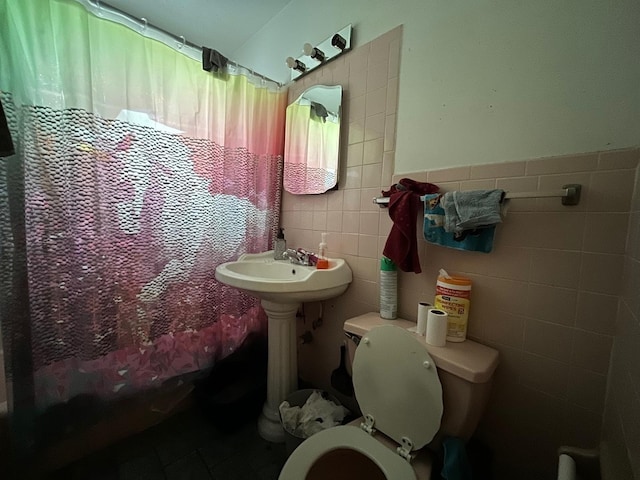 bathroom featuring tile flooring, tile walls, and toilet