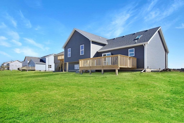 rear view of property with a shingled roof, a lawn, and a wooden deck