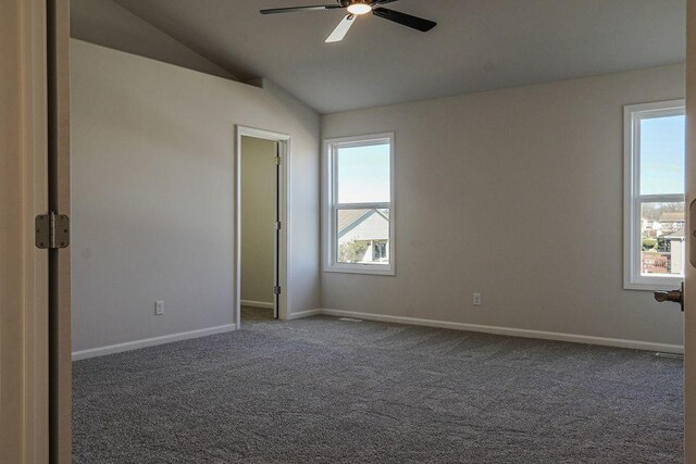 8357 Dylan Dr, Merrillville, IN 46410 - empty room featuring vaulted ceiling, dark carpet, and baseboards