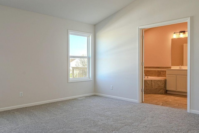 8357 Dylan Dr, Merrillville, IN 46410 - unfurnished bedroom with baseboards, ensuite bathroom, vaulted ceiling, carpet flooring, and a sink