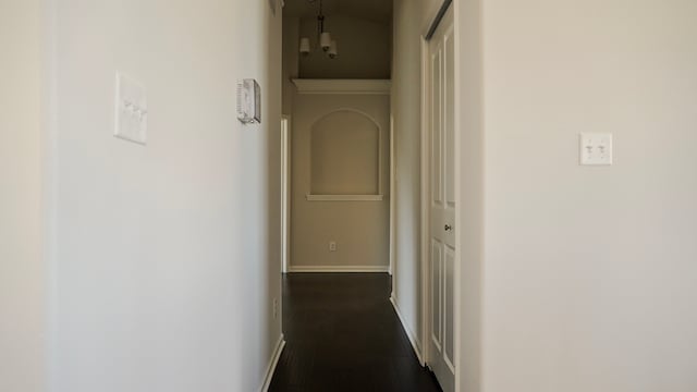 hall with dark wood-style floors and baseboards