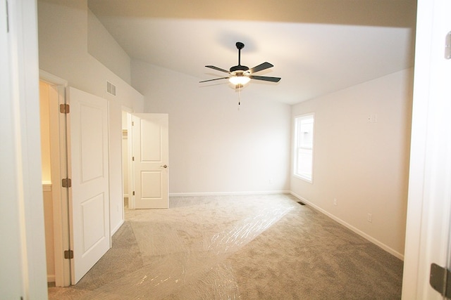 unfurnished room featuring ceiling fan, lofted ceiling, light carpet, visible vents, and baseboards