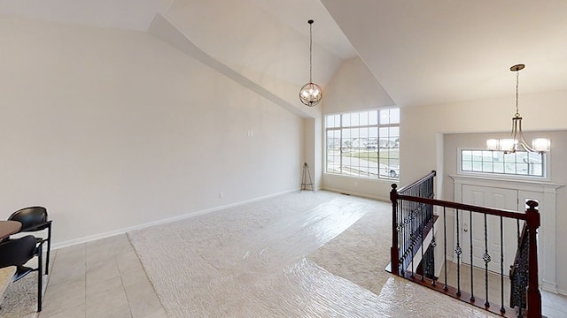 interior space with an inviting chandelier, baseboards, and vaulted ceiling