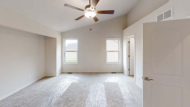 unfurnished room with light colored carpet, lofted ceiling, visible vents, and baseboards