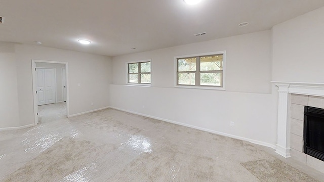 unfurnished living room featuring baseboards, visible vents, concrete flooring, and a tile fireplace