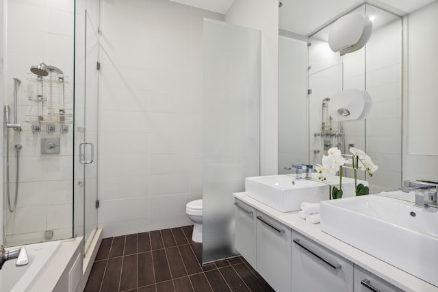 bathroom with tile walls, tile flooring, toilet, dual vanity, and an enclosed shower