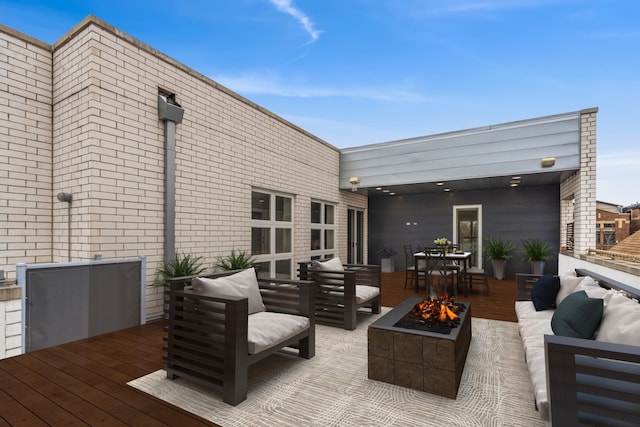 wooden terrace featuring an outdoor living space with a fire pit