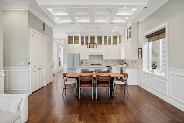 dining room featuring crown molding, dark hardwood / wood-style floors, coffered ceiling, and beamed ceiling