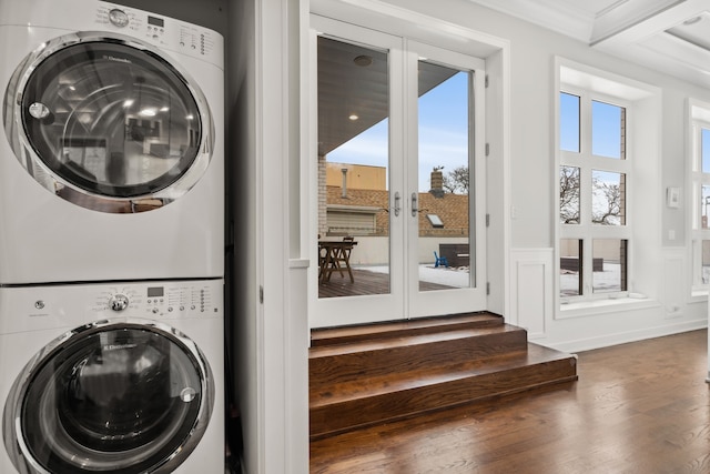 laundry area featuring french doors, ornamental molding, dark hardwood / wood-style floors, and stacked washer and clothes dryer