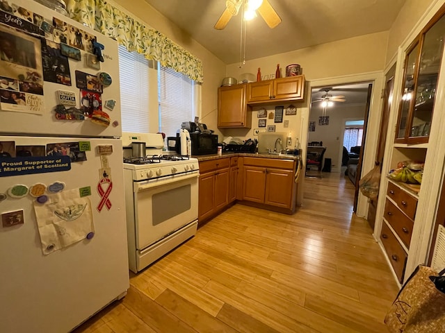 kitchen featuring white appliances, sink, ceiling fan, and light wood-type flooring