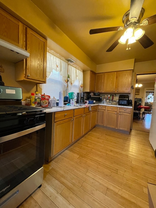 kitchen featuring stainless steel range oven, ceiling fan, and light wood-type flooring