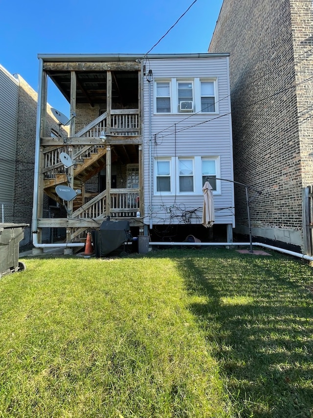 rear view of property with a wooden deck and a lawn