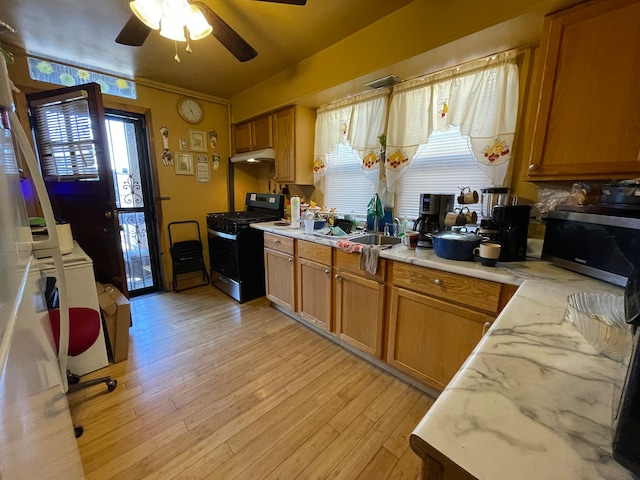 kitchen with ceiling fan, sink, light hardwood / wood-style flooring, light stone counters, and stove