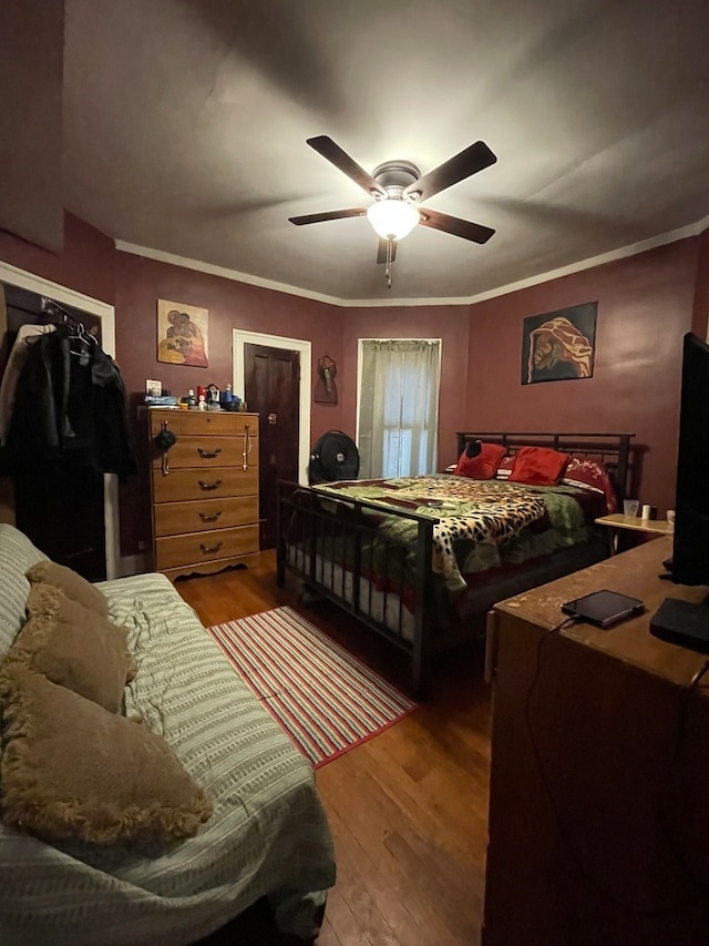 bedroom featuring ceiling fan, crown molding, and hardwood / wood-style flooring