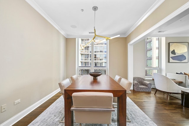 dining space with a notable chandelier, dark wood-type flooring, and crown molding