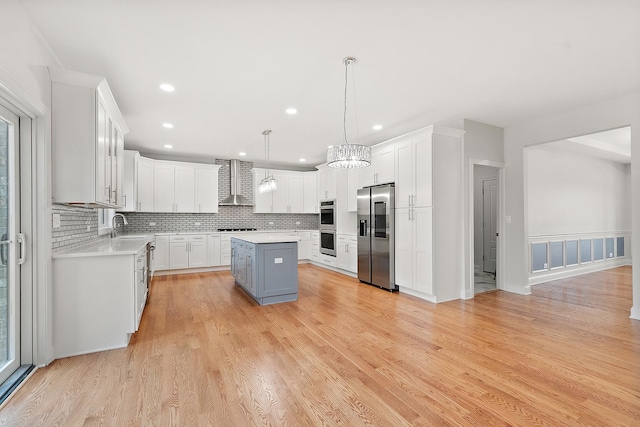 kitchen featuring stainless steel appliances, a sink, a kitchen island, light countertops, and decorative backsplash